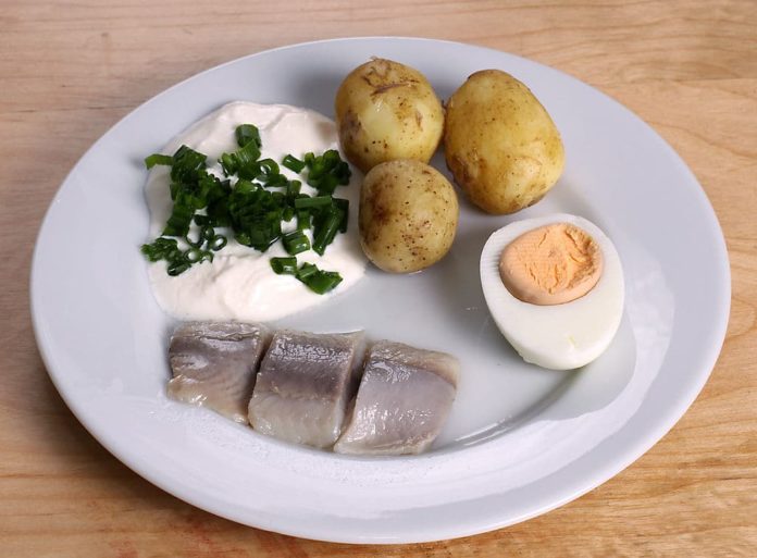 Photo-of-plate-with-herring-potatoes-egg-and-sauce-at-swedish-midsummer