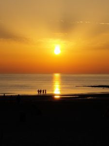 Dutch Beaches: The sun sets with four people in the background at Sintmaartenszee