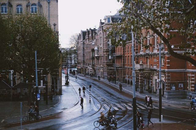 photo-of-dutch-street-towns-on-a-gloomy-rainy-day-with-brown-buildings-and-bikes-and-people-crossing-the-crosswalk