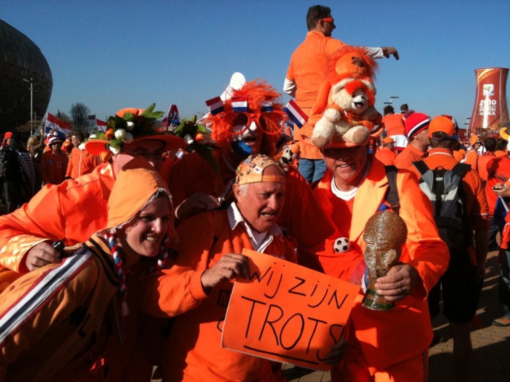 Dutch football fans dressed in orange in crazy costume. 