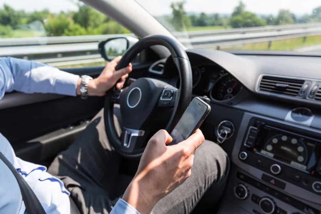 A-person-driving-while-looking-at-the-phone-on-the-motorway