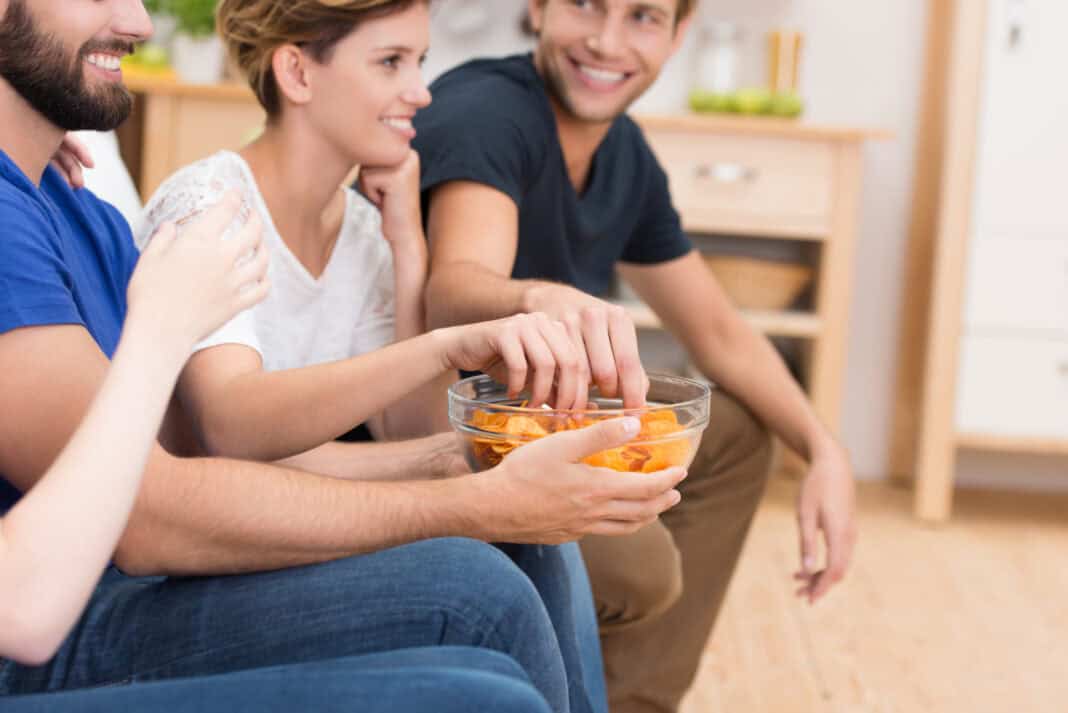 A-photo-of-a-group-of-friends-eating-chips-on-the-sofa