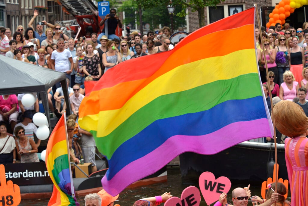 Pride-flag-being-flown-during-a-pride-parade-in-amsterdam-the-netherlands