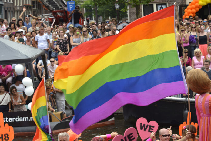 Pride-flag-being-flown-during-a-pride-parade-in-amsterdam-the-netherlands