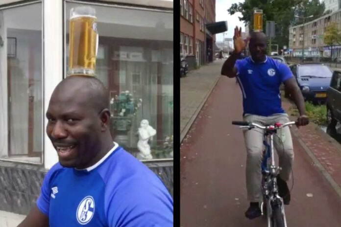 Man-cycles-with-beer-on-head