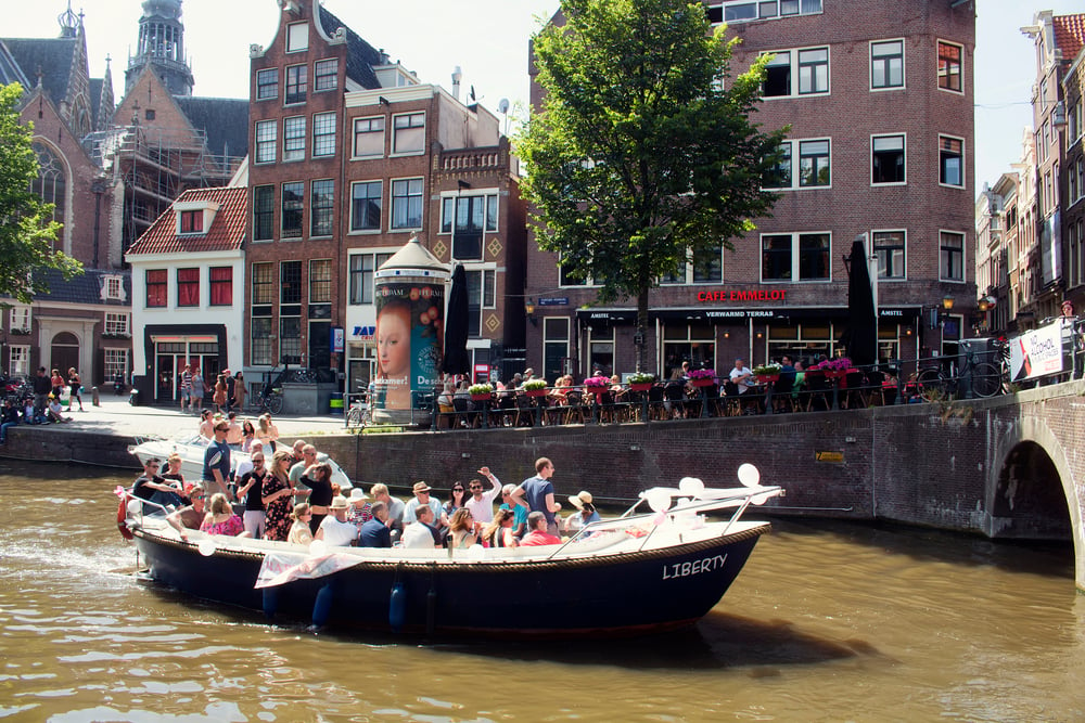Boat-filled-with-a-group-of-happy-people-on-canal-in-Amsterdam