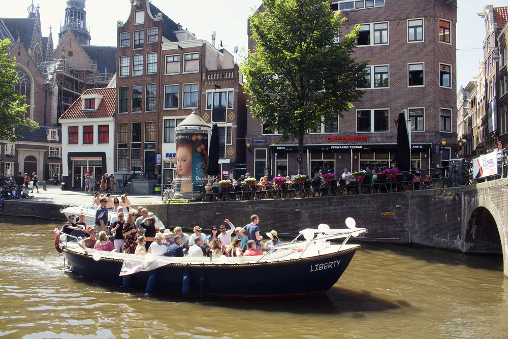 Boat-filled-with-a-group-of-happy-people-on-canal-in-Amsterdam