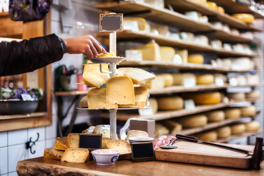 Photo-of-woman-weighing-boerenkaas-in-traditional-Dutch-cheese-shop