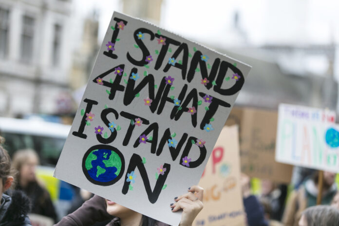photo-of-a-climate-march-with-a-woman-holding-a-sign-that-reads-I-stand-for-what-I-stand-on