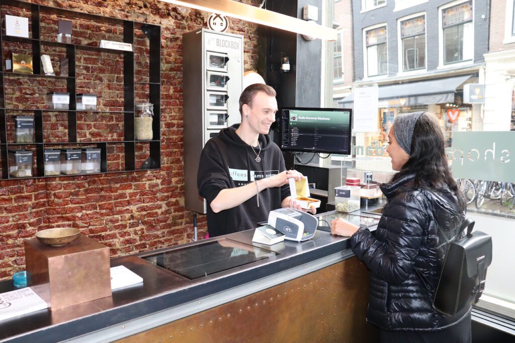 photo-of-interior-of-coffeeshop-amsterdam-with-female-client-being-presented-weed-brownie