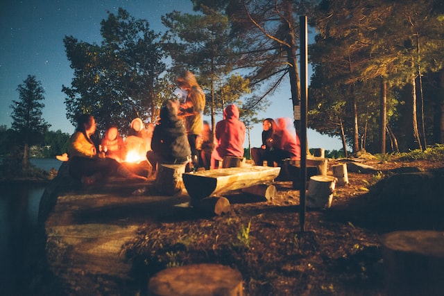 photo-of-group-of-people-by-a-campfire-supporting-mother