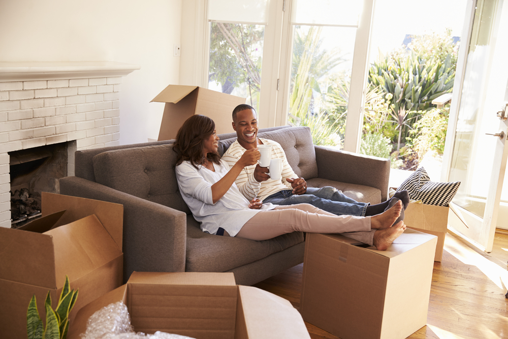 Photo-of-couple-sitting-on-couch-after-finding-and-furnishing-dream-home-with-Dutch-Real-Estate-Company