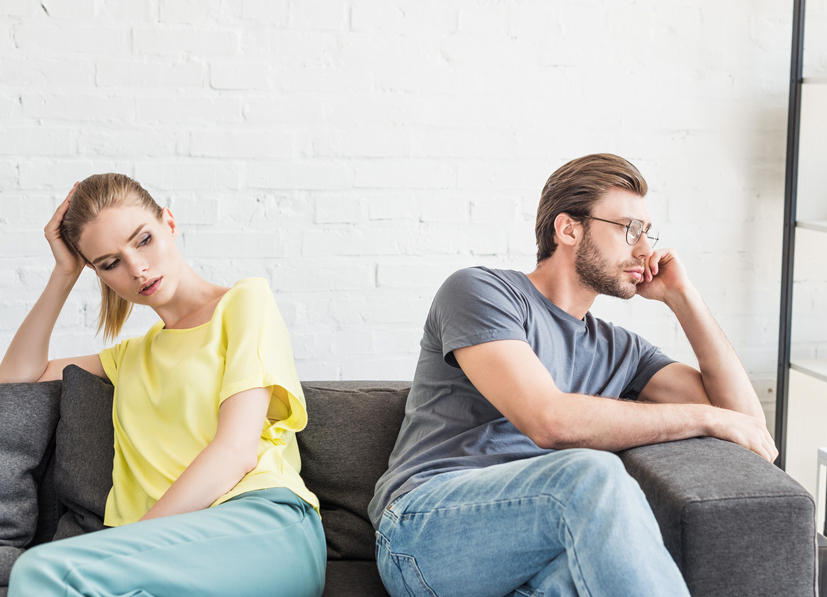 Photo-of-couple-sitting-on-the-couch-fighting