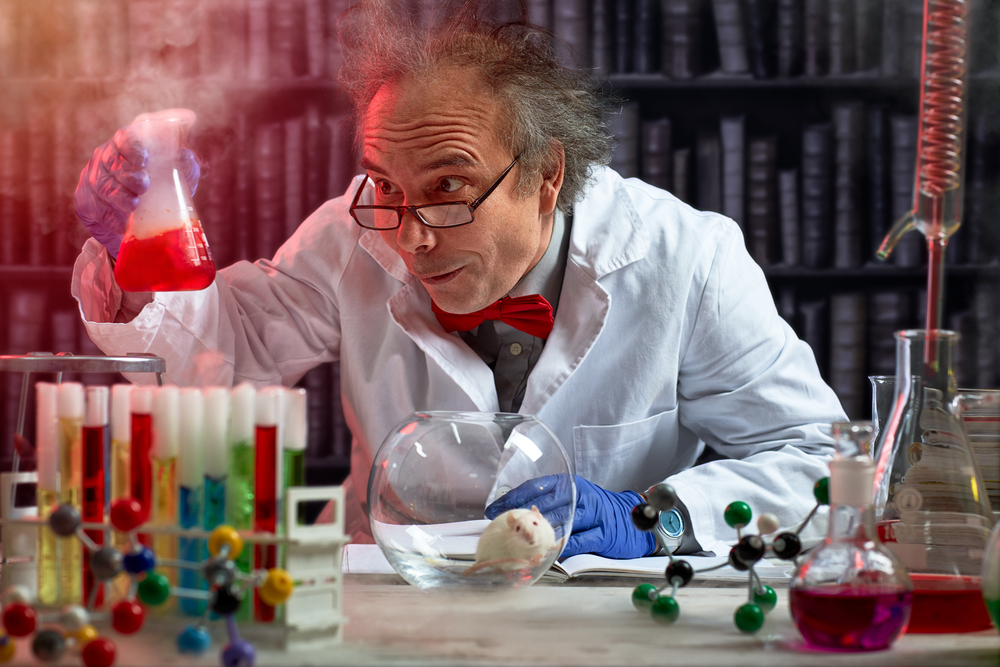 Mad-scientist-with-wild-grey-hair-glasses-and-white-coat-looking-at-experiment-in-test-tube