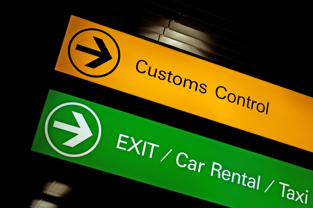 Lit-yellow-customs-control-sign-at-the-airport
