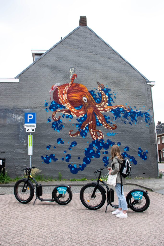 magical-murals-of-Tilburg-photo-of-a-girl-with-an-e-step-in-front-of-a-mural-in-tilburg