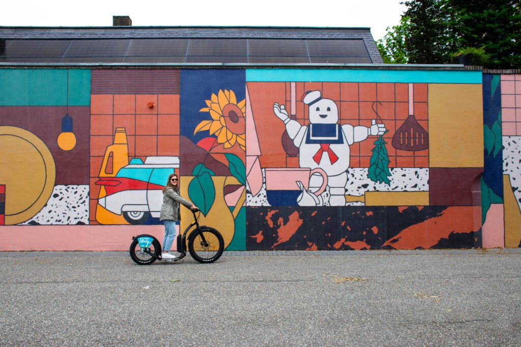 photo-of-a-girl-on-an-e-step-in-front-of-a-mural-in-tilburg