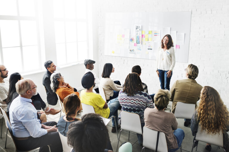 Photo-of-woman-at-recruitment-event-talking-to-attendees-in-office