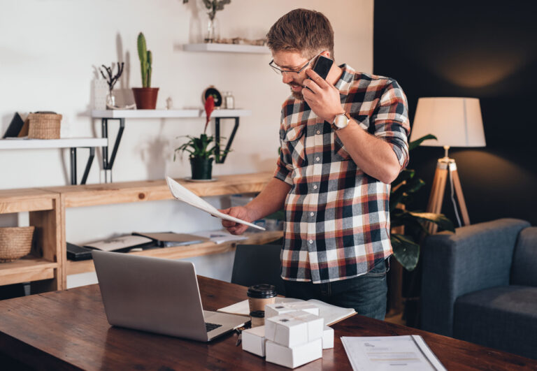 Photo-of-self-employed-man-on-the-phone-paying-taxes