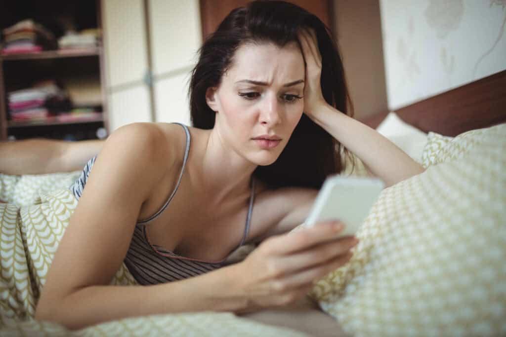 woman-looking-at-her-phone-waiting-for-a-reply-from-her-match-on-a-dating-app