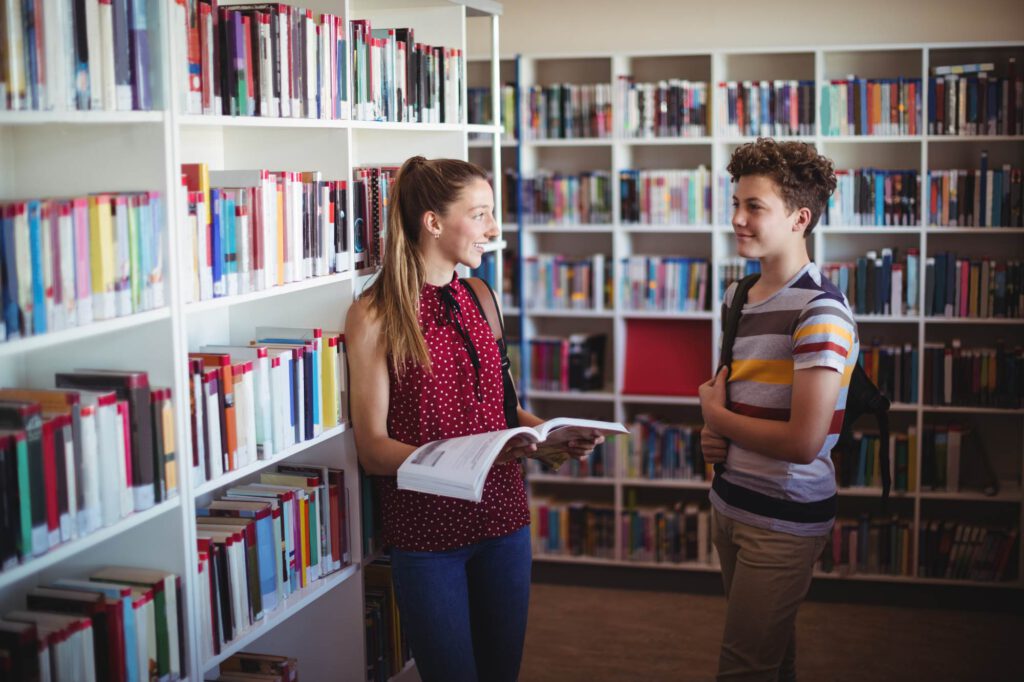 two-Dutch-students-talking-in-the-library-in-an-international-school