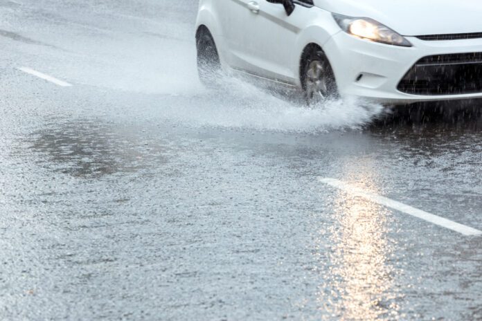 Car-drives-dwn-flooded-road-in-South-Limburg-after-record-breaking-thunderstorm