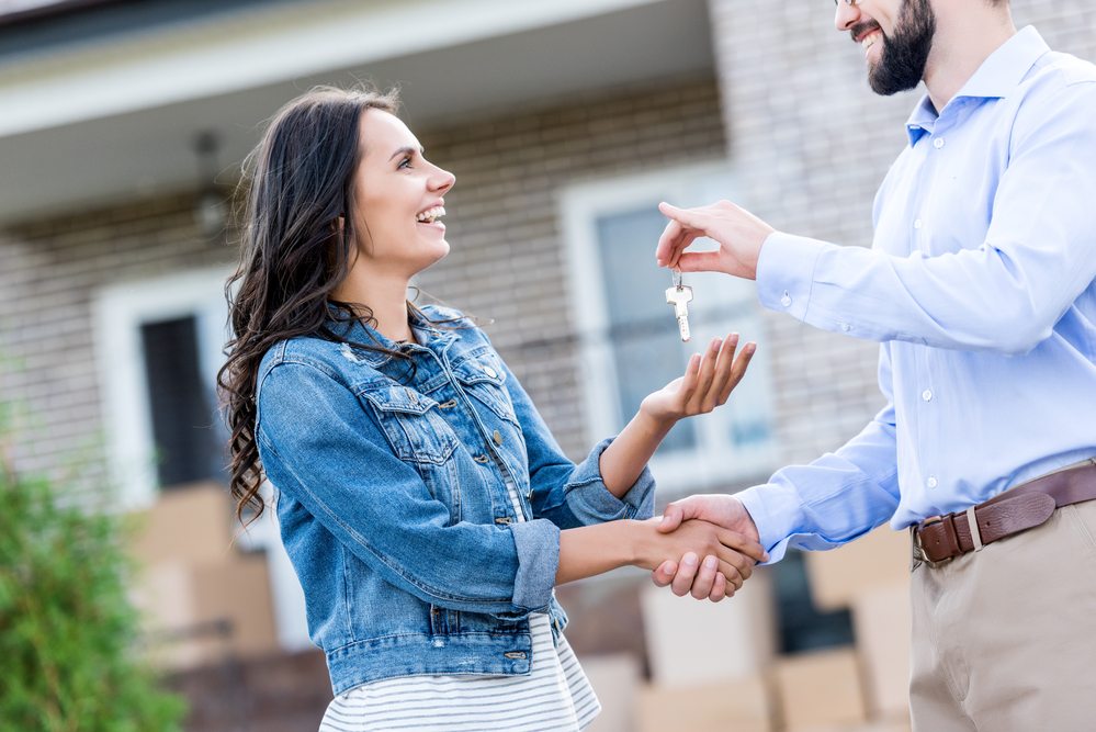 Photo-of-international-buying-a-house-shaking-hands-with-realtor-in-front-of-house-in-the-Netherlands