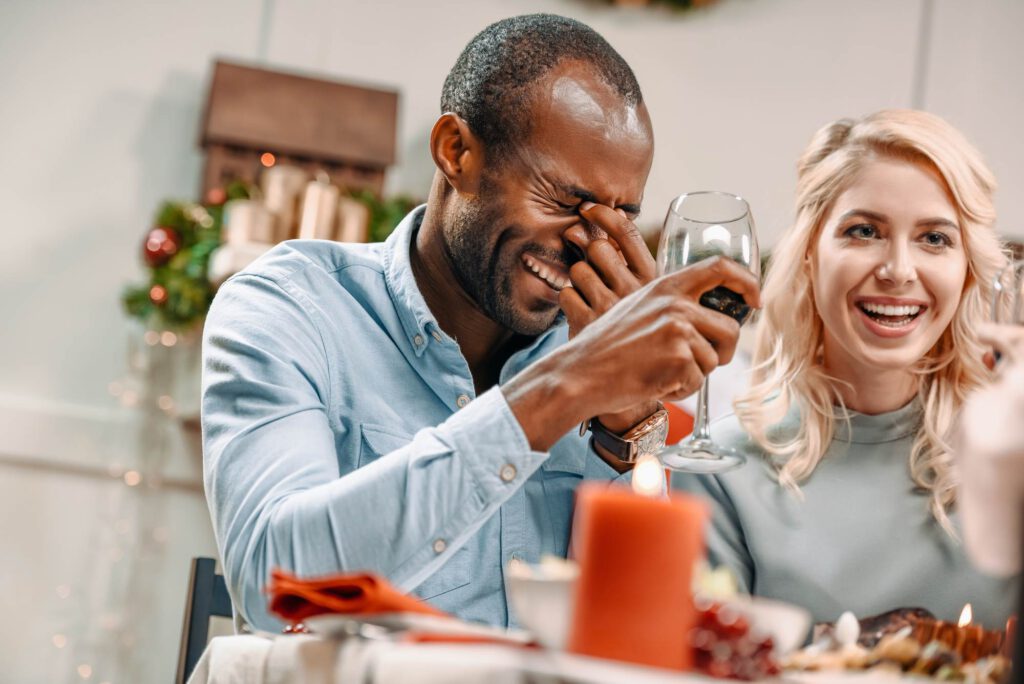 Photo-of-couple-laughing-at-dinner-table-with-wine-enjoying-ways-to-fall-back-in-love-with-learning-Dutch