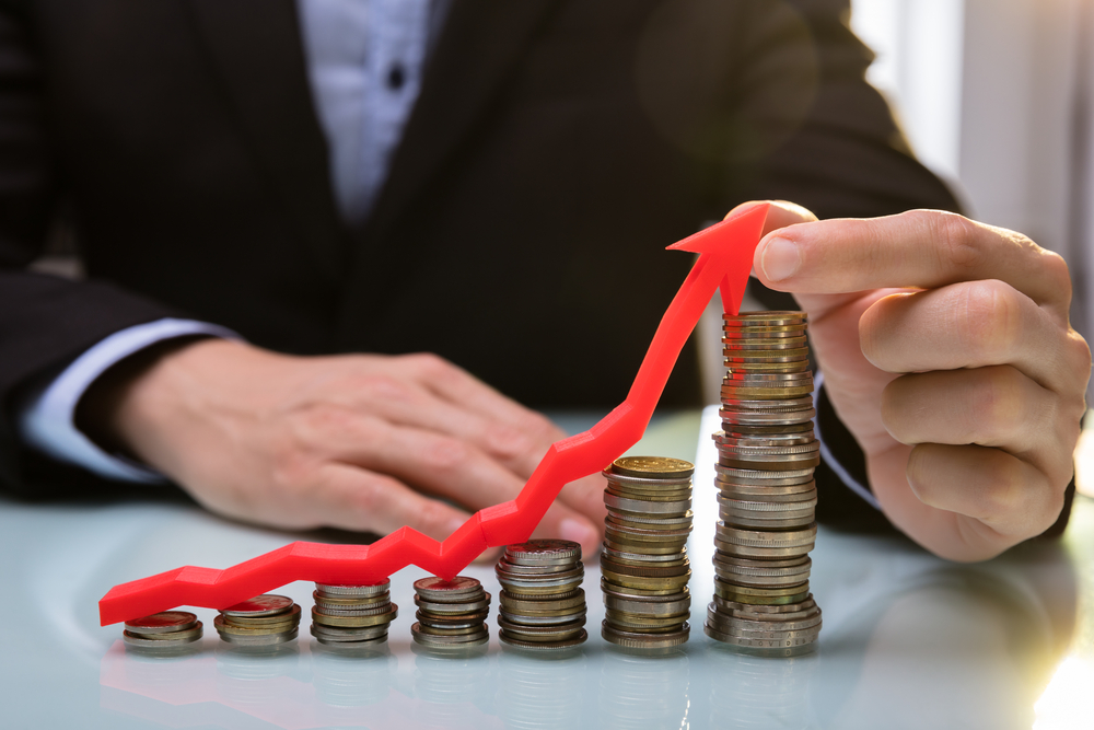 Business-person-in-a-suit-holding-error-over-rising-stack-of-coins-to-show-Dutch-inflation-rate