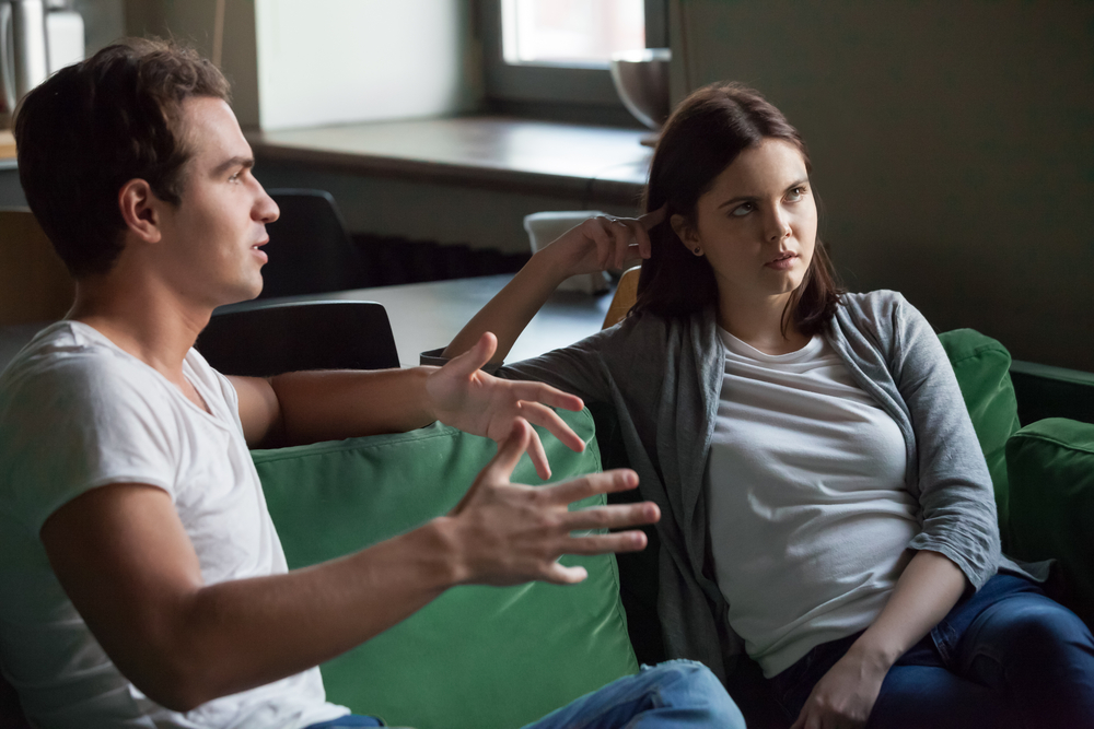 Photo-of-woman-getting-annoyed-at-guy-talking-to-her-on-couch