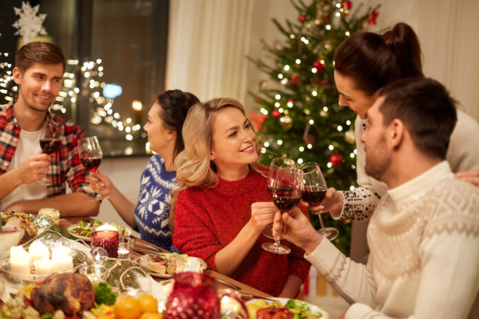 Group-of-Dutchies-celebrating-Christmas-with-wine-and-food-and-Christmas-tree-in-the-back