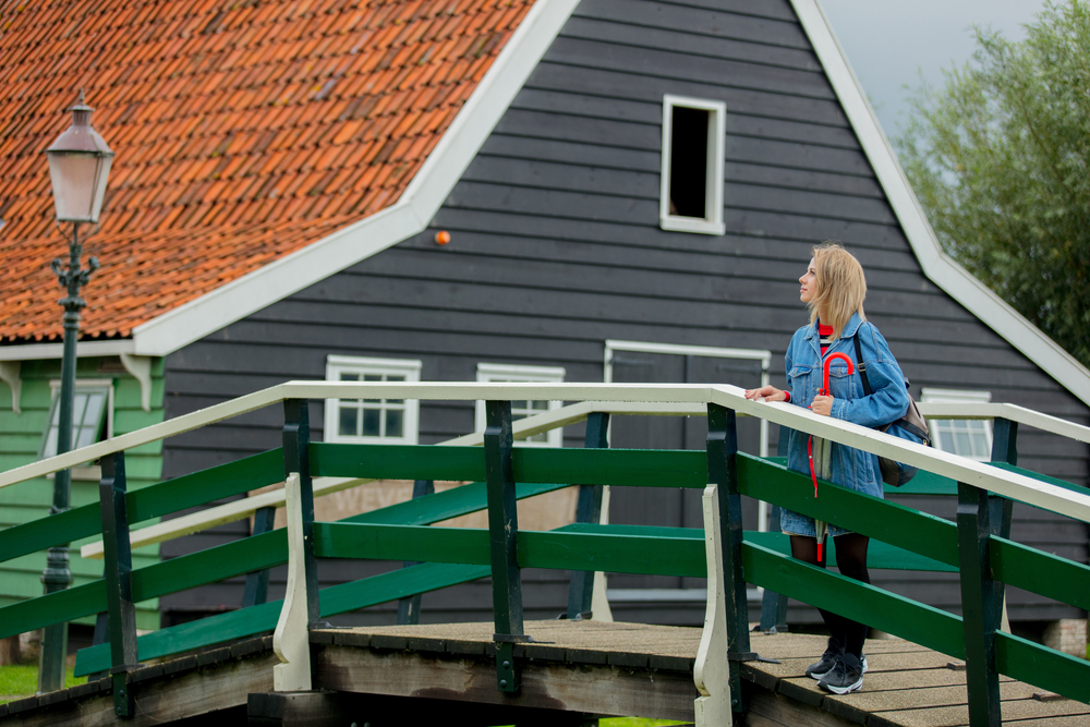 Woman-standing-on-bridge-looking-at-houses-in-Netherlands