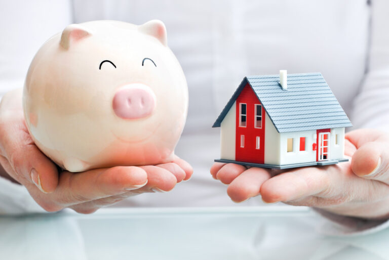 Photo-of-woman-holding-piggy-bank-and-miniature-house-saving-money-Netherlands