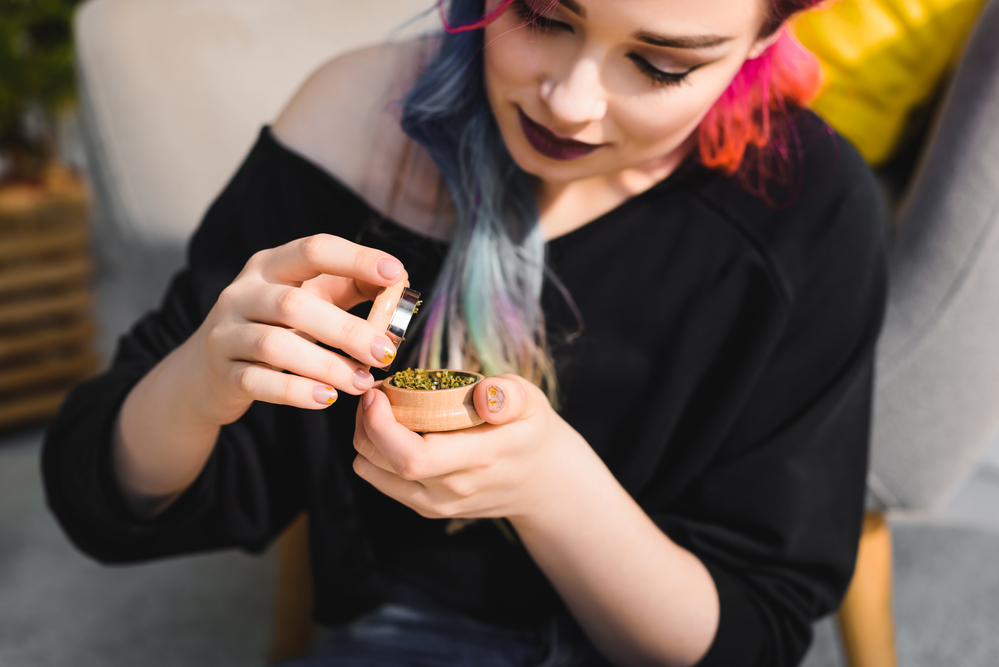 Girl-with-colourful-hair-preparing-weed-in-a-grinder