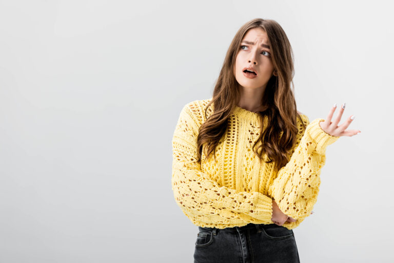 Confused-girl-wearing-a-yellow-sweater-looking-unsure
