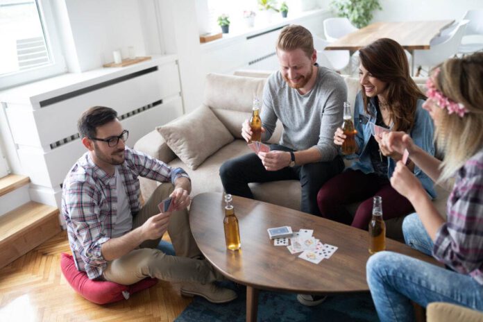 photo-of-a-happy-group-of-friends-playing-cards-and-drinking