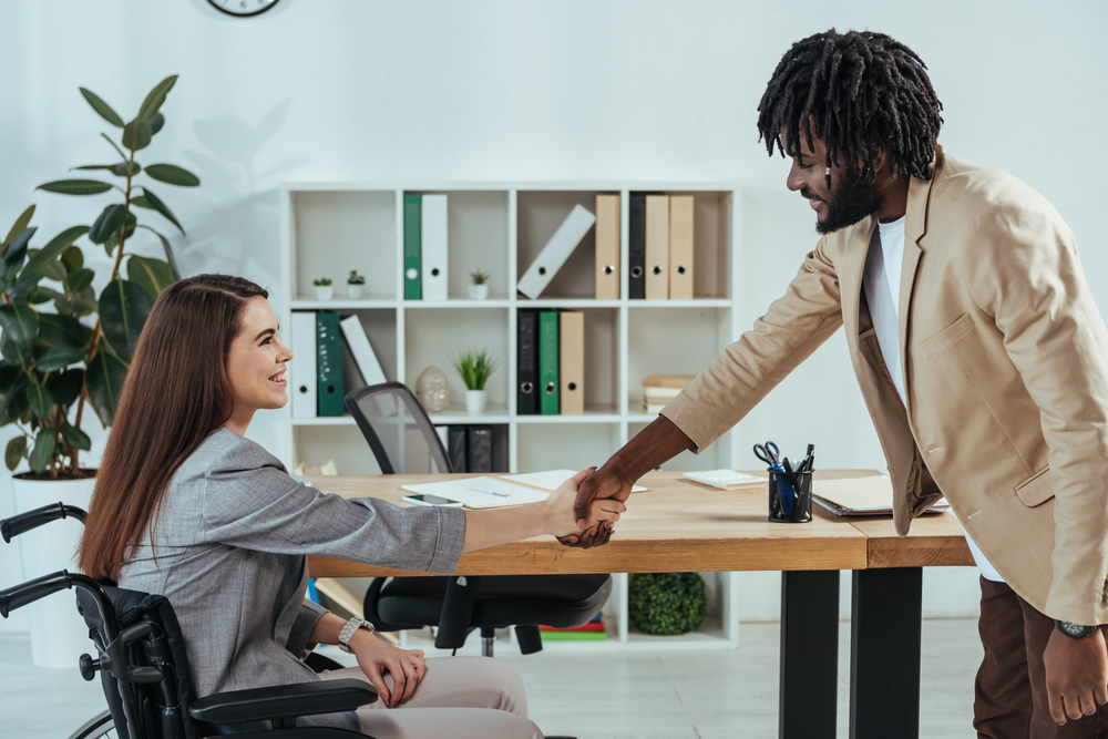 Photo-of-woman-in-wheelchair-shaking-hands-with-interviewer-at-job-interview-in-the-Netherlands