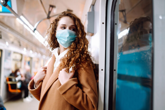 photo-of-a-woman-traveling-on-the-metro-wearing-a-facemask