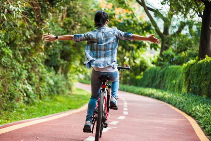 photo-of-woman-riding-mountain-bike-with-her-arms-outstretched