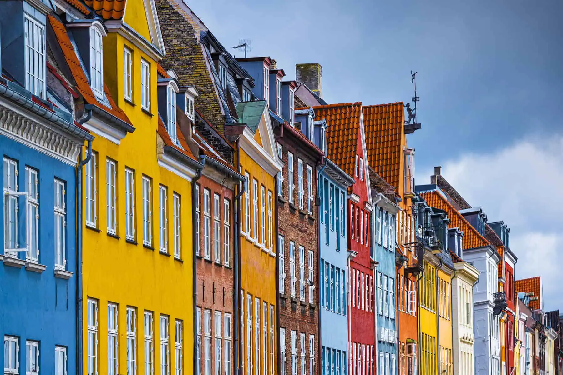 photo-of-colourful-row-of-houses-in-copenhagen-with-bridge-boat-water