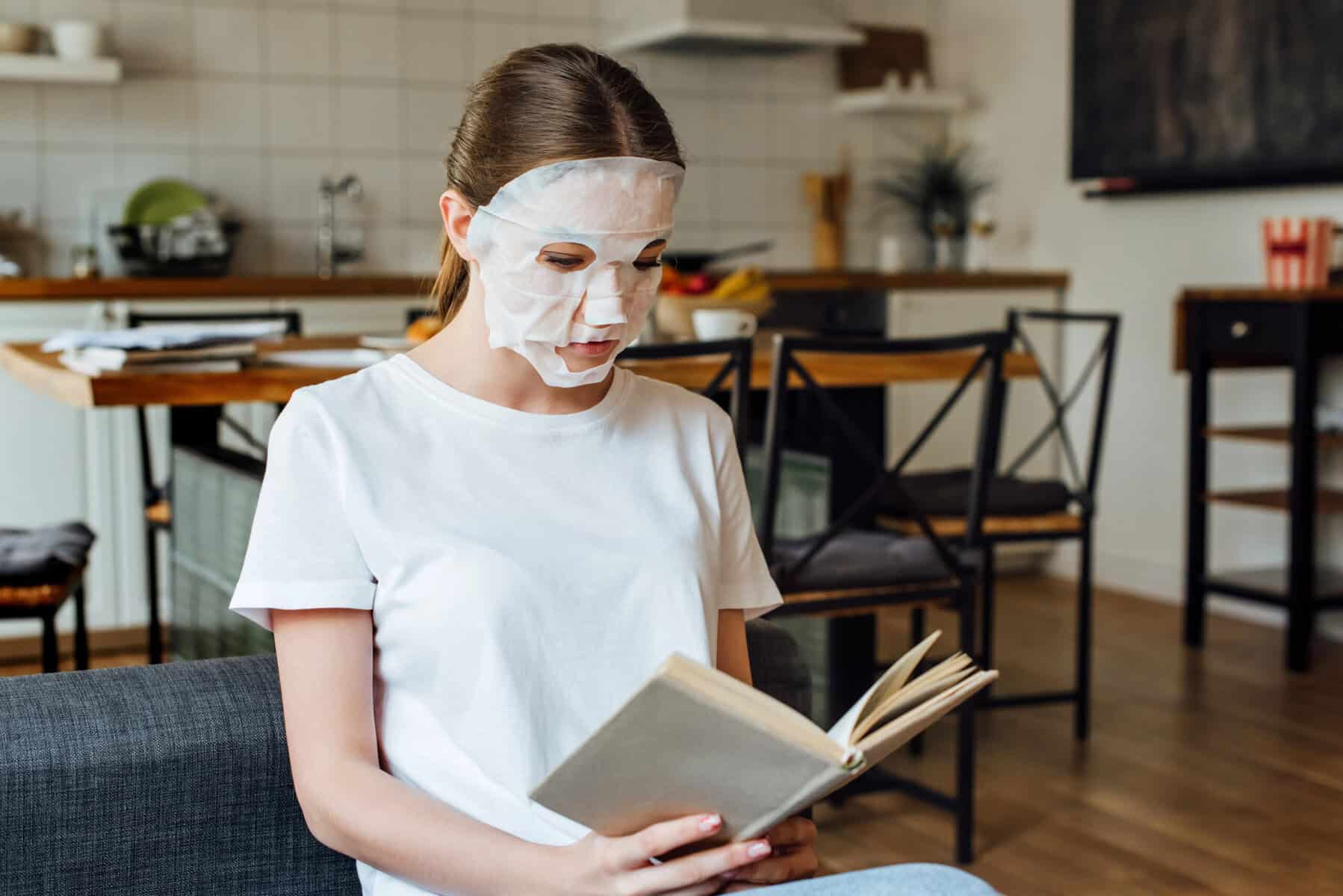 woman-in-her-house-wearing-a-face-mask-relaxing-and-reading-a-book