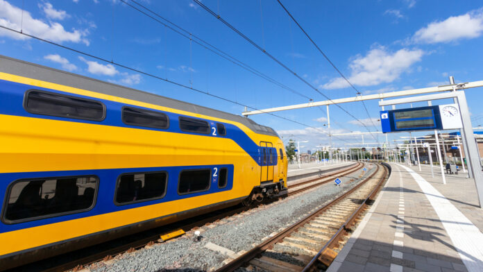 Yellow-and-blue-Dutch-NS-train-running-through-train-station