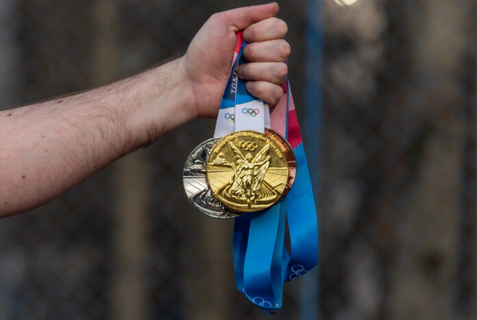 photo-athlete-holding-olympic-medals-from-tokyo-2021