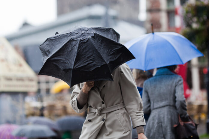 Rainy-weather-with-people-shielding-themsevles-from-the-wind-and-rain-with-umbrellas