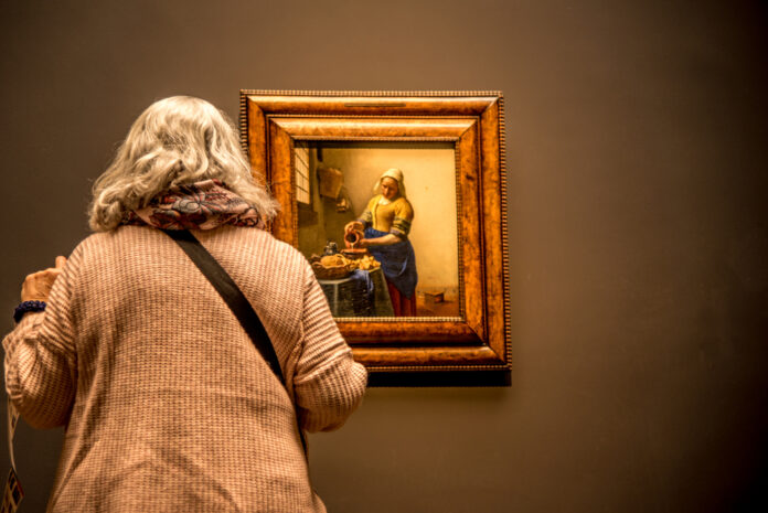 photo-of-an-older-woman-looking-at-a-Vermeer-painting-at-the-Rijksmuseum