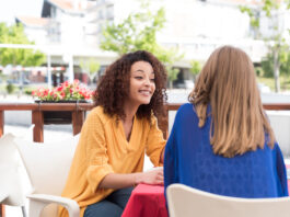 Photo-of-two-women-sitting-talking-Dutch-together-outside-friends-summer-day-cafe