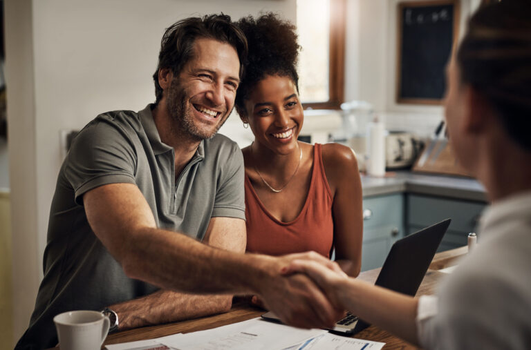 Photo-of-smiling-couple-shaking-hands-with-Dutch-mortgage-advisor