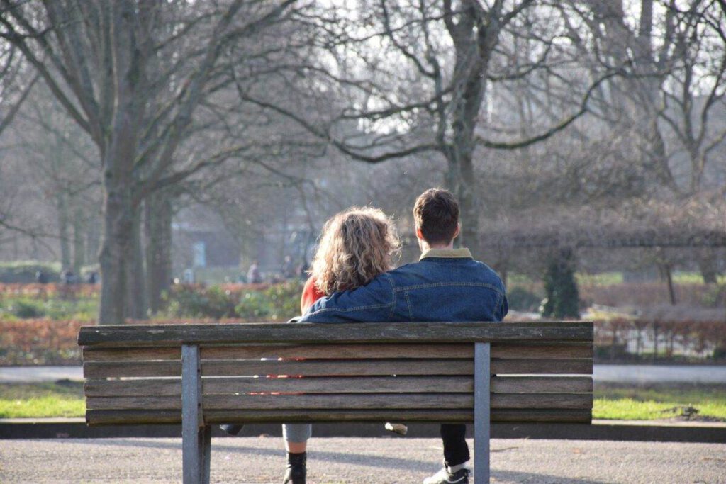 couple-sitting-on-a-bench-in-Amserdam-in-winter-after-moving-to-the-Netherlands-for-love