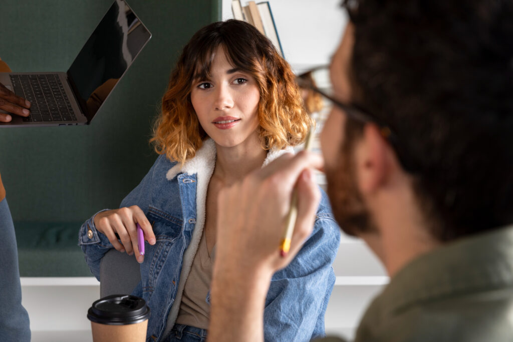 photo-of-woman-in-Dutch-class-sitting-at-desk-talking-to-man-during-Dutch-course-in-Amsterdam