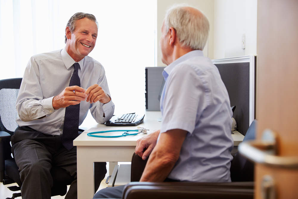 Dutch-doctor-and-senior-patient-sitting-across-each-other-in-pratice-during-consultation